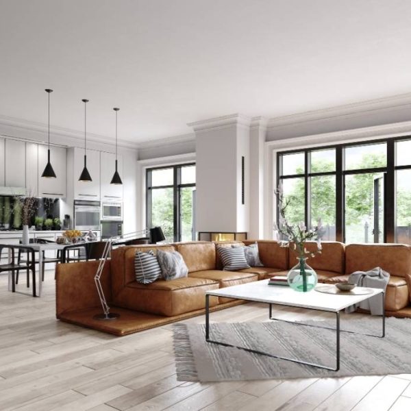 Modern open-concept vacation rental with sleek kitchen, floor-to-ceiling windows, and large leather sectional—ideal for big groups and stylish gatherings