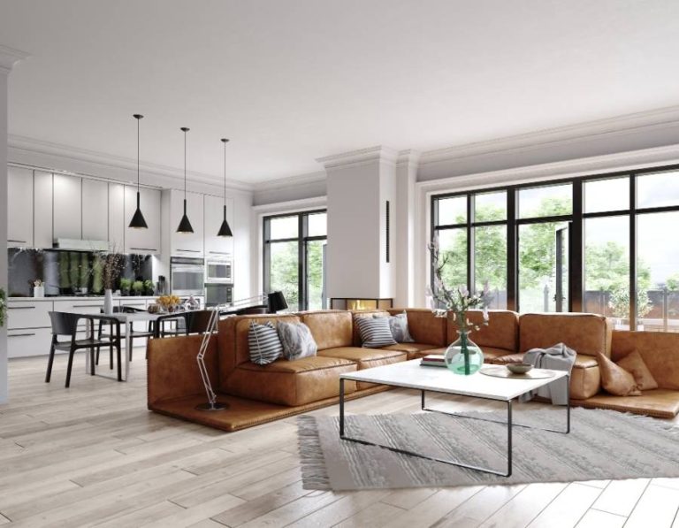 Modern open-concept vacation rental with sleek kitchen, floor-to-ceiling windows, and large leather sectional—ideal for big groups and stylish gatherings