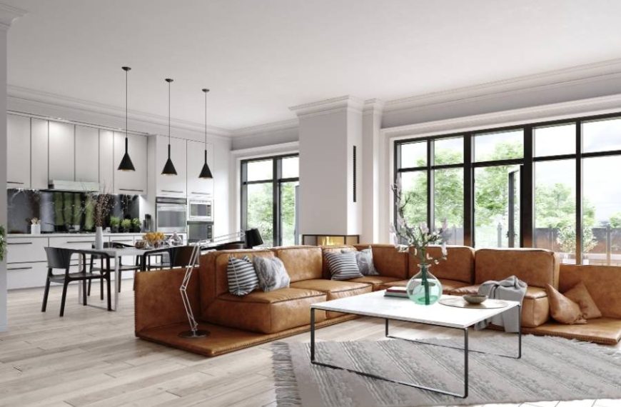 Modern open-concept vacation rental with sleek kitchen, floor-to-ceiling windows, and large leather sectional—ideal for big groups and stylish gatherings