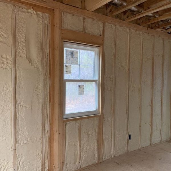 Spray foam insulation installed inside a residential interior wall in a Bluffton, South Carolina home during new construction, featuring exposed wood framing, energy-efficient closed-cell foam insulation, and unfinished wall studs designed for coastal humidity and storm protection.