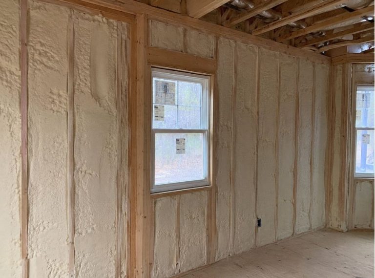 Spray foam insulation installed inside a residential interior wall in a Bluffton, South Carolina home during new construction, featuring exposed wood framing, energy-efficient closed-cell foam insulation, and unfinished wall studs designed for coastal humidity and storm protection.